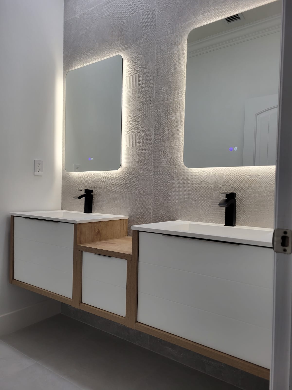 Bathroom with backlit LED mirrors and floating vanity